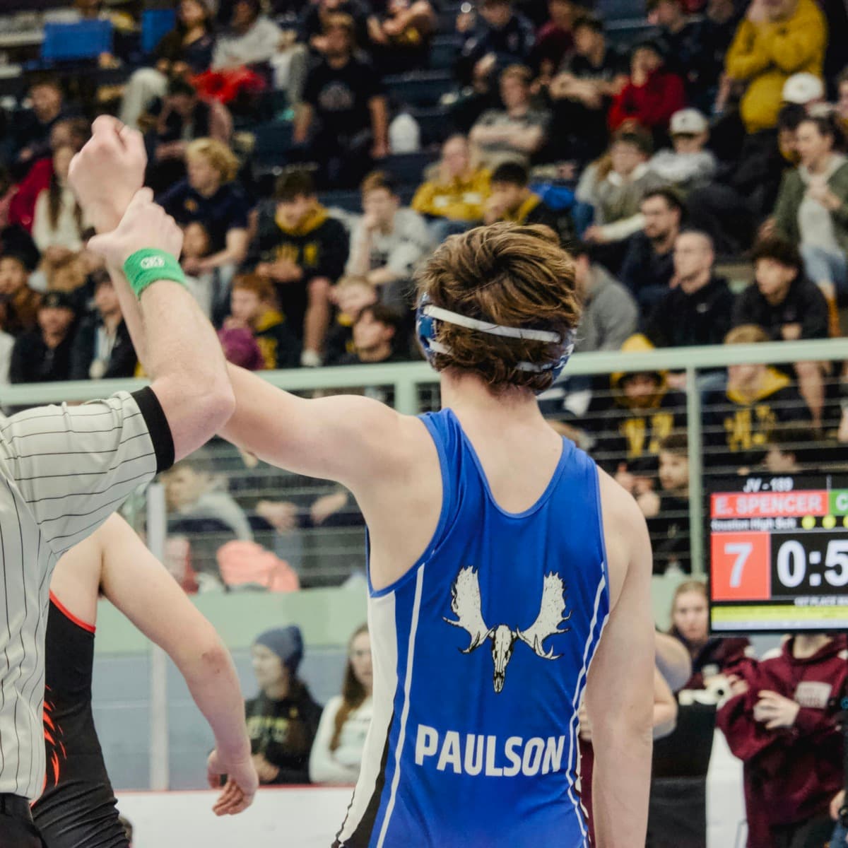 High school wrestler getting his hand raised after a tournament win