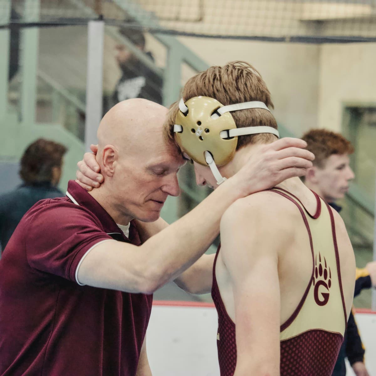 Wrestling coach with his athlete after a match