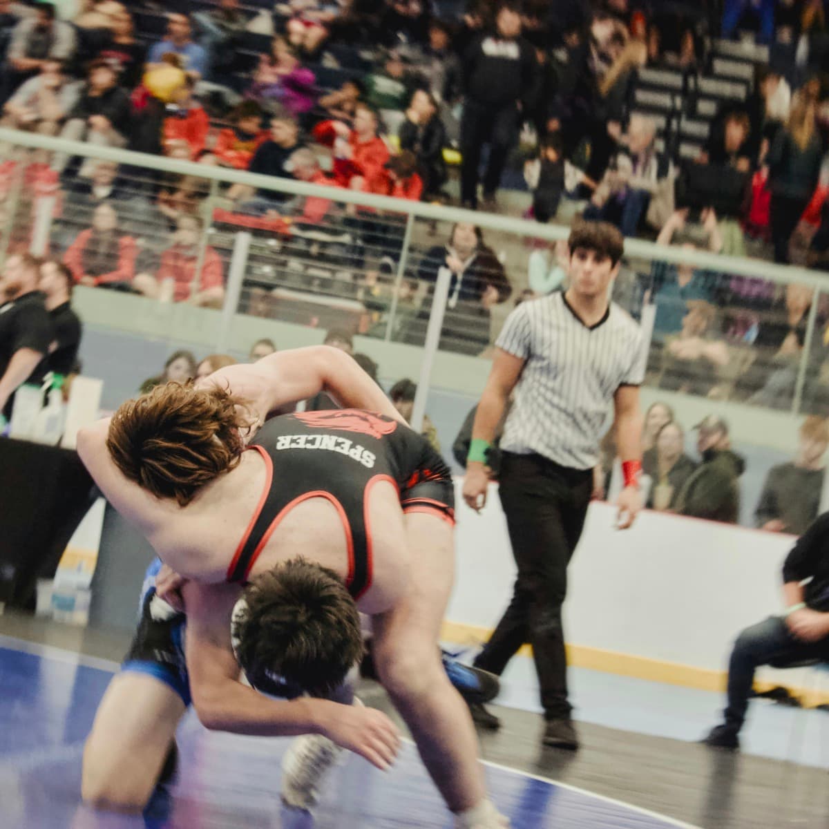 Two high school wrestlers in a takedown sequence